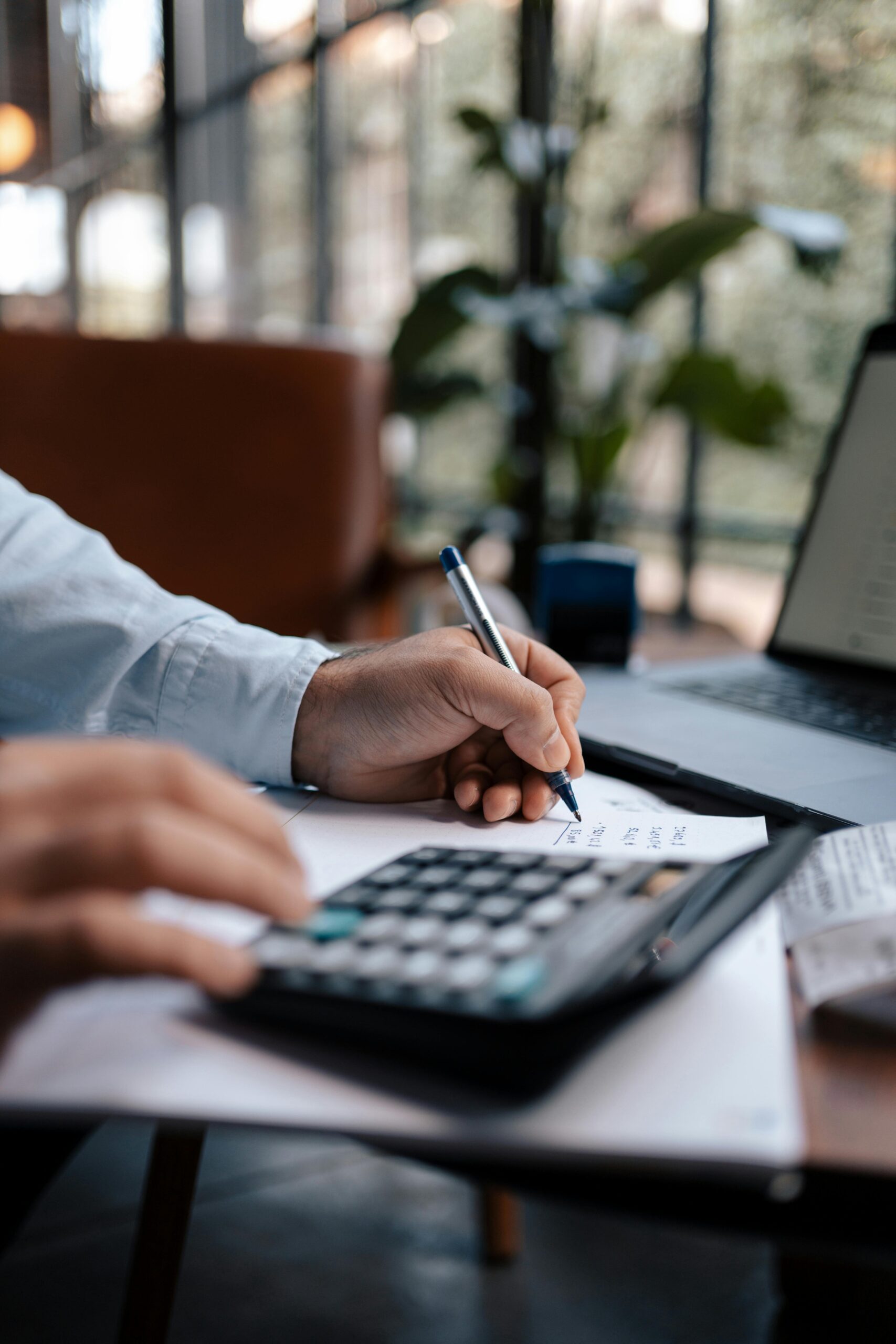 Invest-Smart-Grow-Fast-Your-Small-Business-Guide-to-IT-Expense-Planning-scaledjpg Free A person calculating finances with a calculator and pen on a desk indoors. Stock Photo